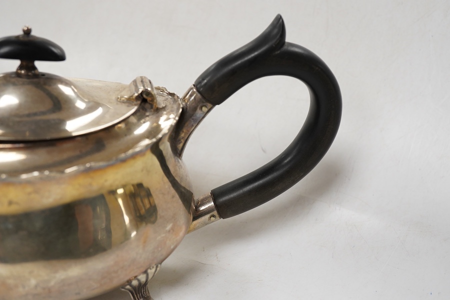 A late Victorian silver oval teapot, William Hutton & Sons, London, 1899, together with a George III silver cream jug, London, 1811, gross weight 15.4oz.